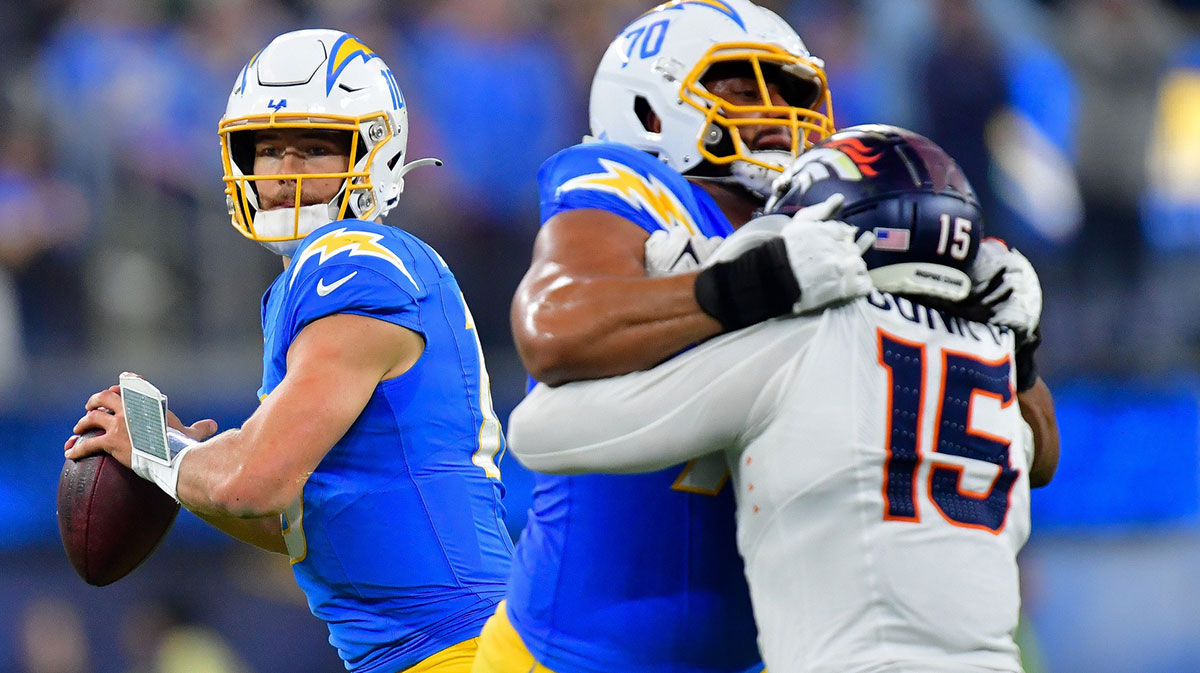 Los Angeles Chargers quarterback Justin Herbert (10) drops back to pass as offensive tackle Rashawn Slater (70) provides coverage against Denver Broncos linebacker Nik Bonitto (15) during the second half at SoFi Stadium.