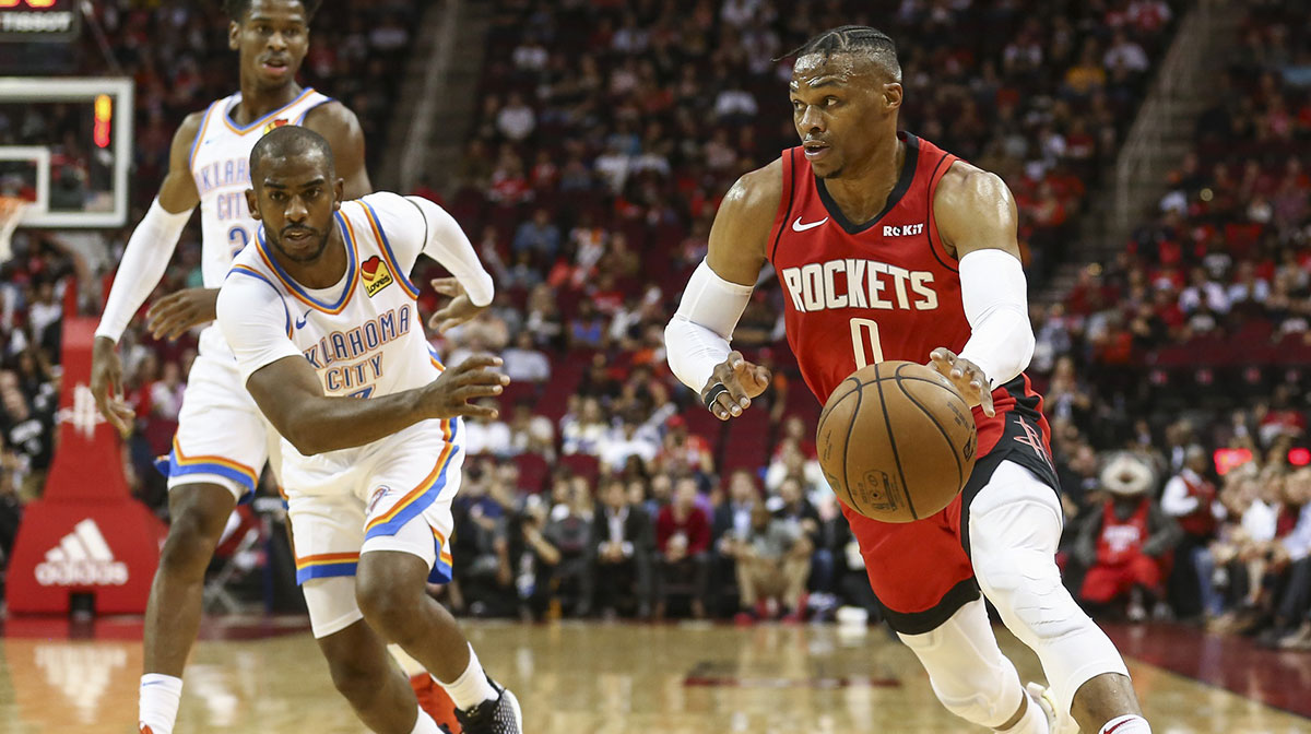 Houston Rockets guard Russell Westbrook (0) dribbles the ball as Oklahoma City Thunder guard Chris Paul (3) defends during the first quarter at Toyota Center.