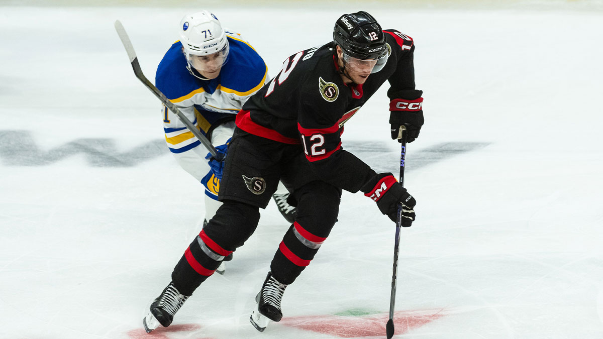 Ottawa Senators center Shane Pinto (12) skates with the puck in front of Buffalo Sabres center Ryan McLeod (71) in the third period at the Canadian Tire Centre.