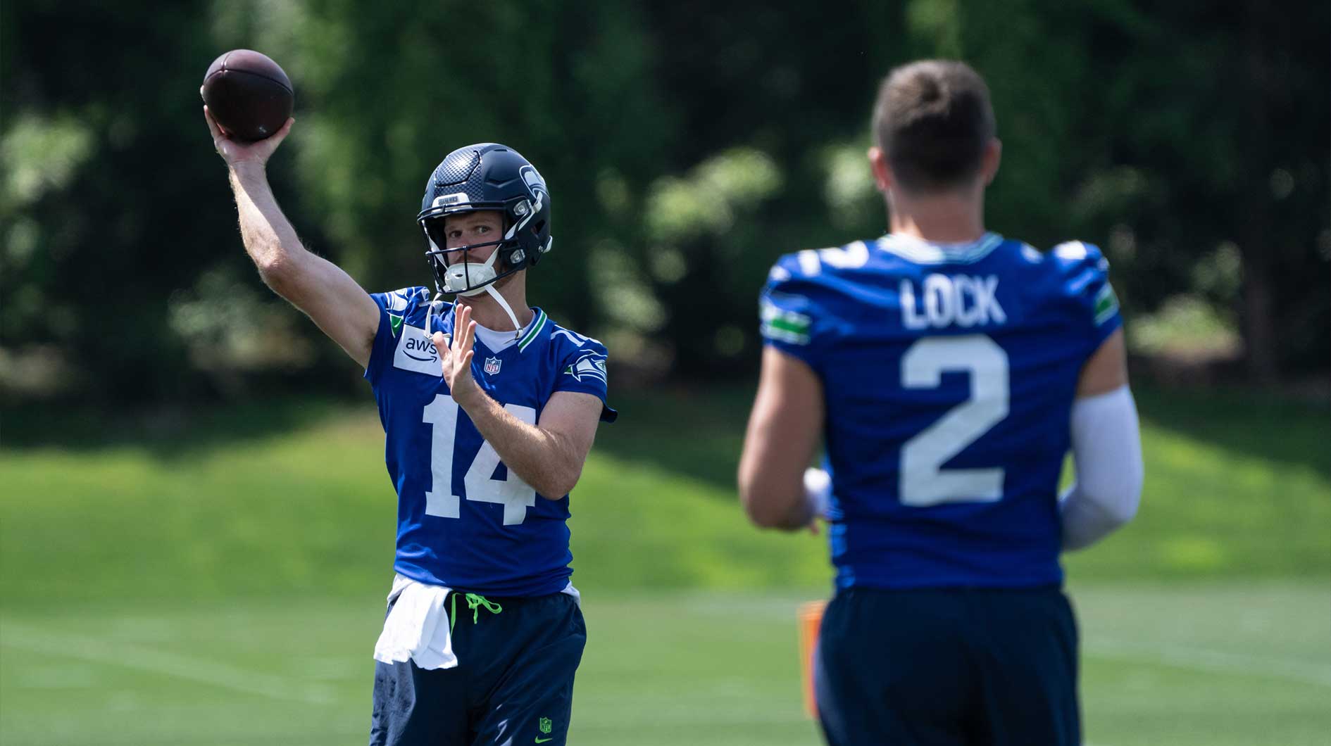 Seattle Seahawks quarterback Sam Darnold (14) passes the ball to quarterback Drew Lock (2) during mini-camp at Virginia Mason Athletic Center.