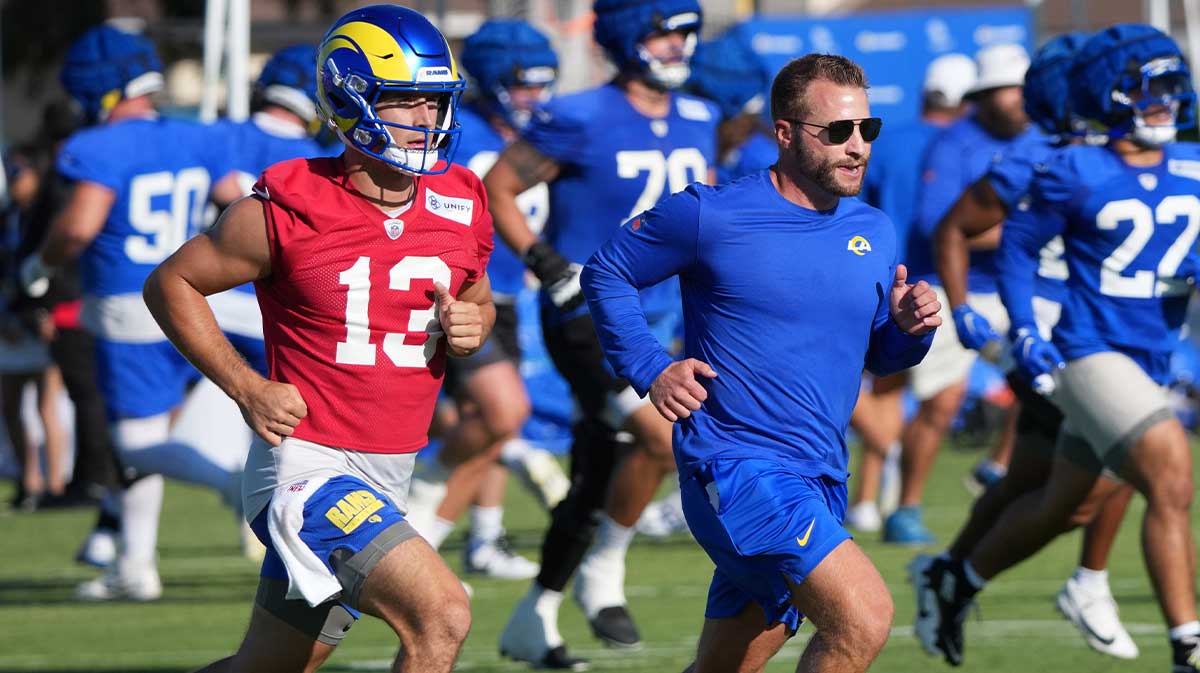 Los Angeles Rams coach Sean McVay runs with quarterback Stetson Bennett (13) during training camp at Loyola Marymount University.