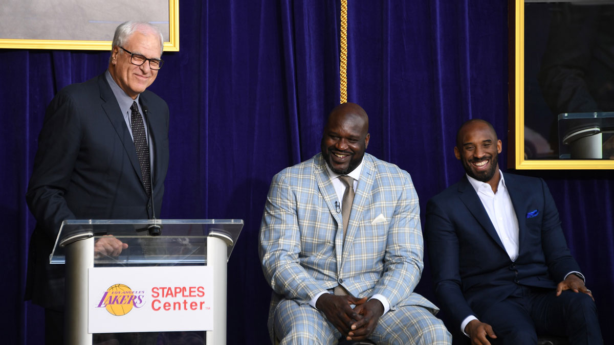 Phil Jackson (left) speaks during ceremony to unveil statue of Los Angeles Lakers former center Shaquille ONeal (center) as Kobe Bryant (right) listens at Staples Center.