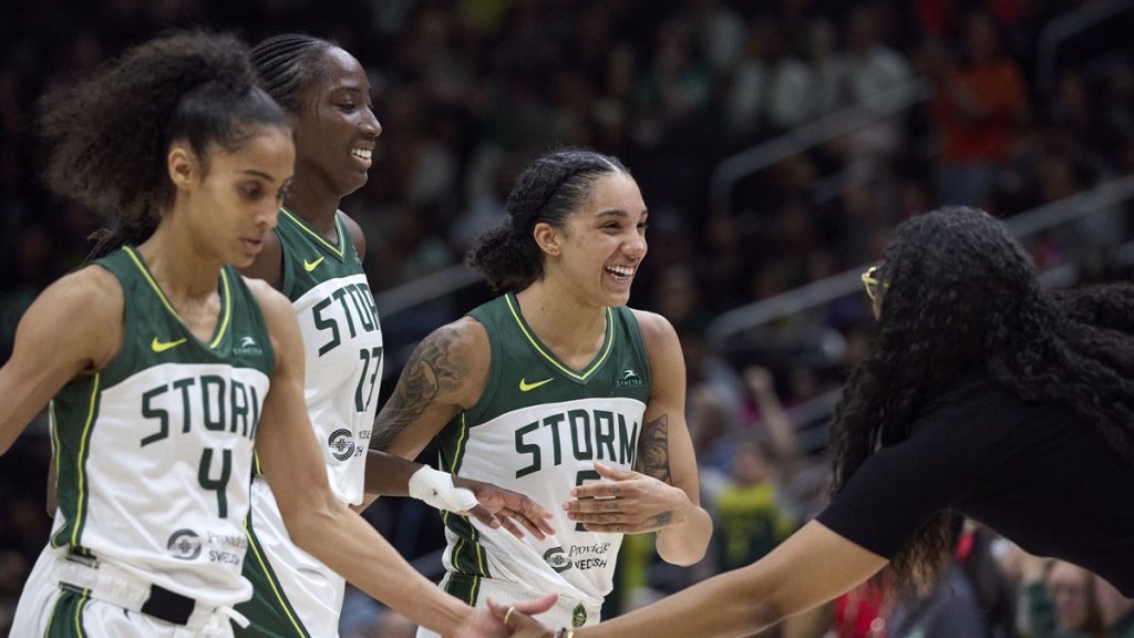 Seattle Storm guard Skylar Diggins (4), Seattle Storm forward Ezi Magbegor (13) and Seattle Storm forward Gabby Williams (5) are greeted by head coach Nowlle Quinn during a time out against the Connecticut Sun.