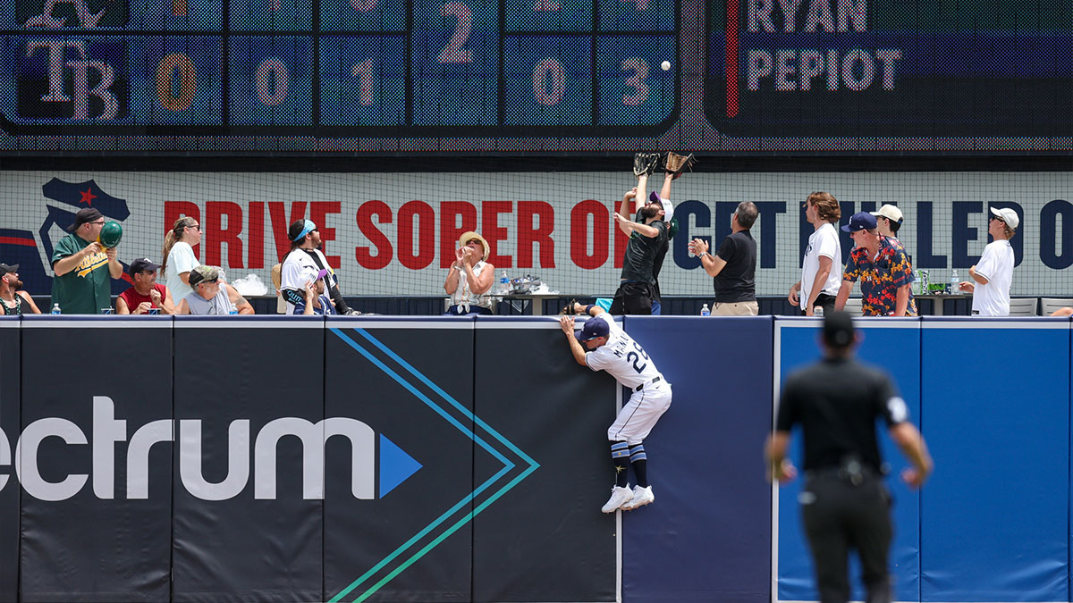 Tampa Bay Rays left fielder Jake Mangum (28) leaps for a ball over the wall against the Oakland Athletics in the second inning at George M. Steinbrenner Field.