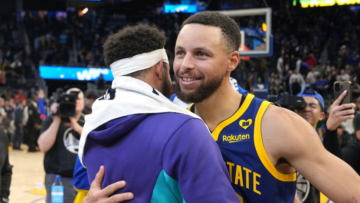 Golden State Warriors guard Stephen Curry (right) hugs Charlotte Hornets guard Seth Curry (left) after the game at Chase Center.