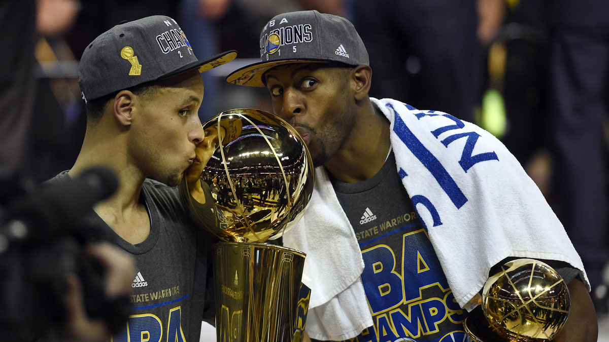 Golden State Warriors guard Stephen Curry (30) poses with the Larry O'Brien Trophy as Golden State Warriors guard Andre Iguodala (9) celebrates with the NBA Finals MVP trophy after beating the Cleveland Cavaliers in game six of the NBA Finals at Quicken Loans Arena.