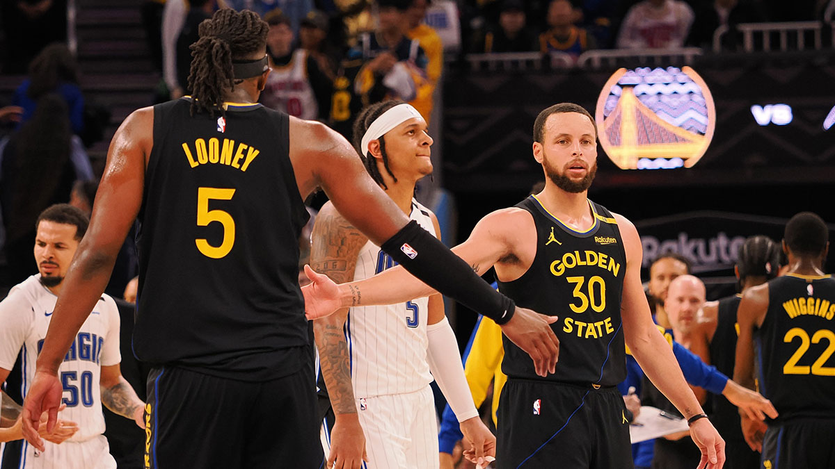 Golden State Warriors guard Stephen Curry (30) high fives forward Kevon Looney (5) as a timeout is called during the fourth quarter against the Orlando Magic at Chase Center.