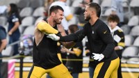 Pittsburgh Steelers linebackers T.J. Watt (90) and Nick Herbig (51) work out before a game against the Dallas Cowboys at Acrisure Stadium.
