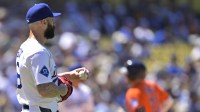 Los Angeles Dodgers relief pitcher Tanner Scott (66) looks on as Houston Astros catcher Yainer Diaz (21) rounds the bases after hitting a solo home run in the eighth inning at Dodger Stadium.