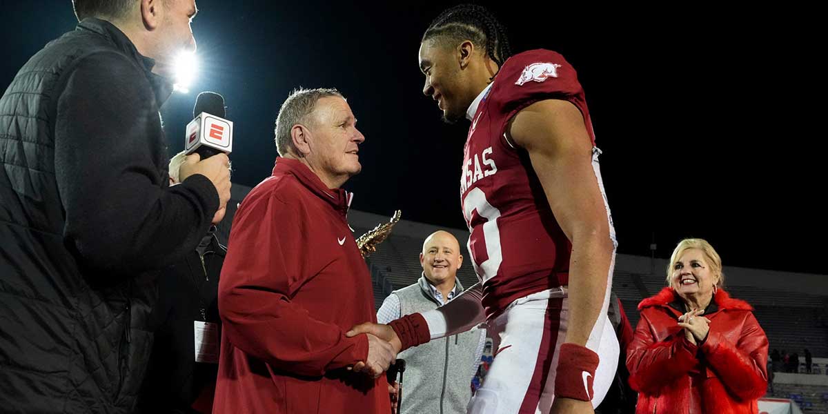 Arkansas' head coach Sam Pittman shakes hands with Taylen Green (10), who was awarded the MVP trophy, after Arkansas defeated Texas Tech 36-26 in the AutoZone Liberty Bowl in Memphis, Tenn., on Friday, December 27, 2024.