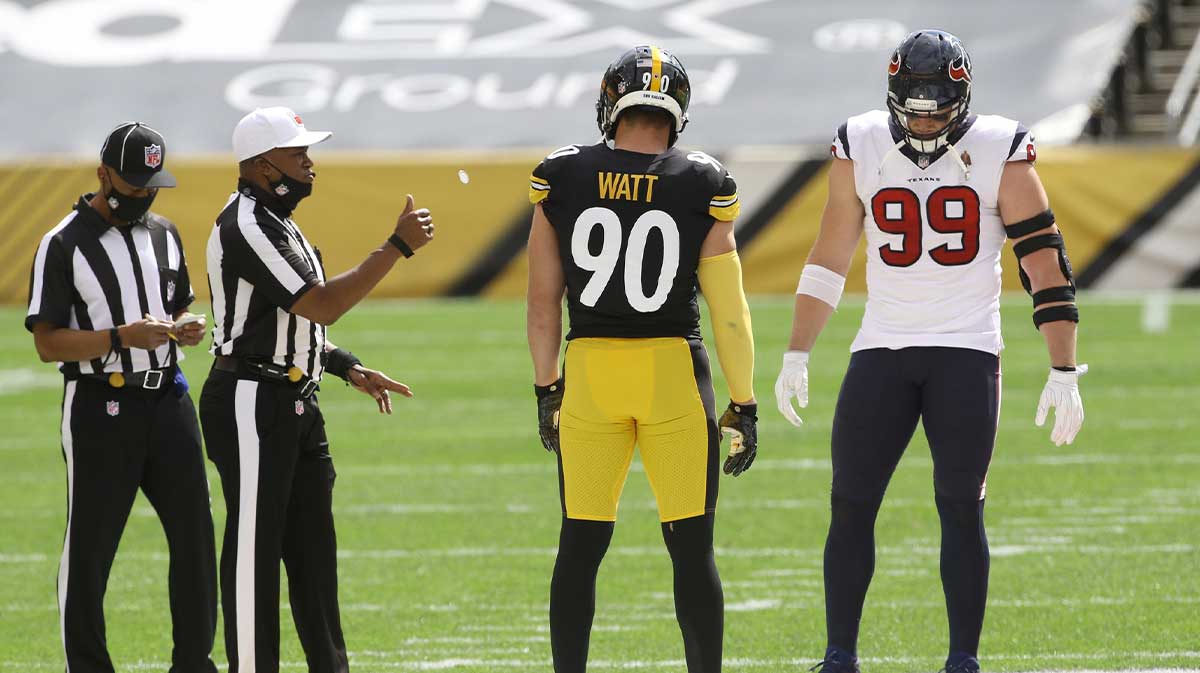 NFL referee Shawn Smith (14) flips the coin as brothers Pittsburgh Steelers outside linebacker T.J. Watt (90) and Houston Texans defensive end J.J. Watt (99) take part before their game against at Heinz Field. The Steelers won 28-21.