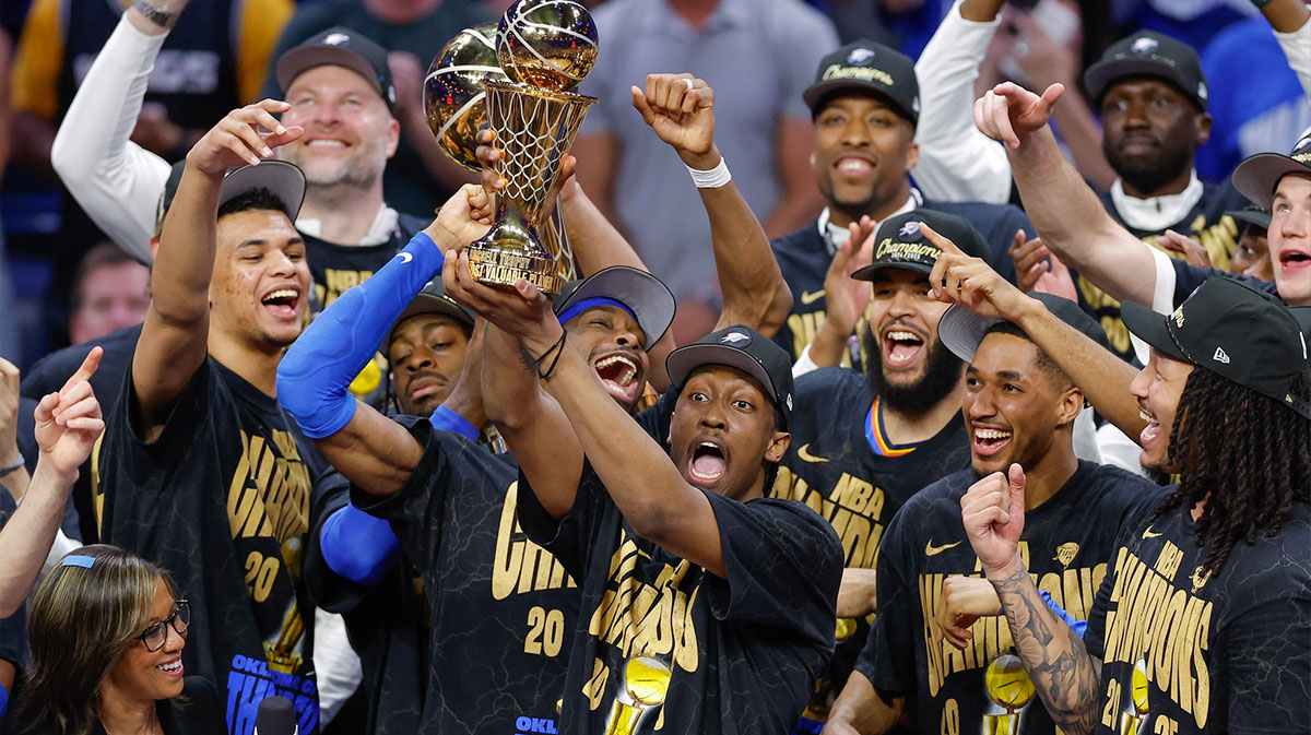 Thunder forward Jalen Williams (8) holds up the Bill Russell NBA Finals MVP trophy after winner Oklahoma City Thunder guard Shai Gilgeous-Alexander hands it to him at the end of game seven of the 2025 NBA Finals against the Indiana Pacers at Paycom Center