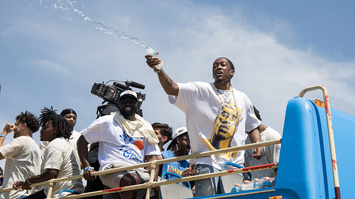 Thunder player Jalen Williams splashes water on fans during the 2025 NBA Oklahoma City Thunder championship parade