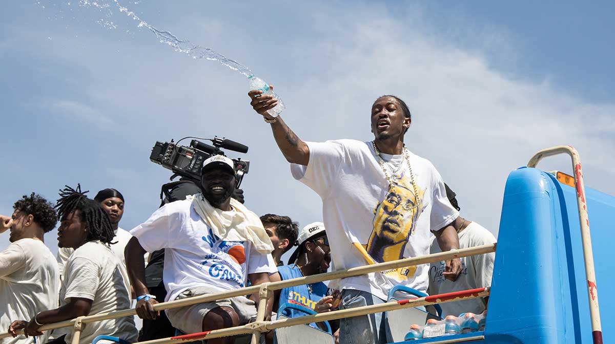 Thunder player Jalen Williams splashes water on fans during the 2025 NBA Oklahoma City Thunder championship parade