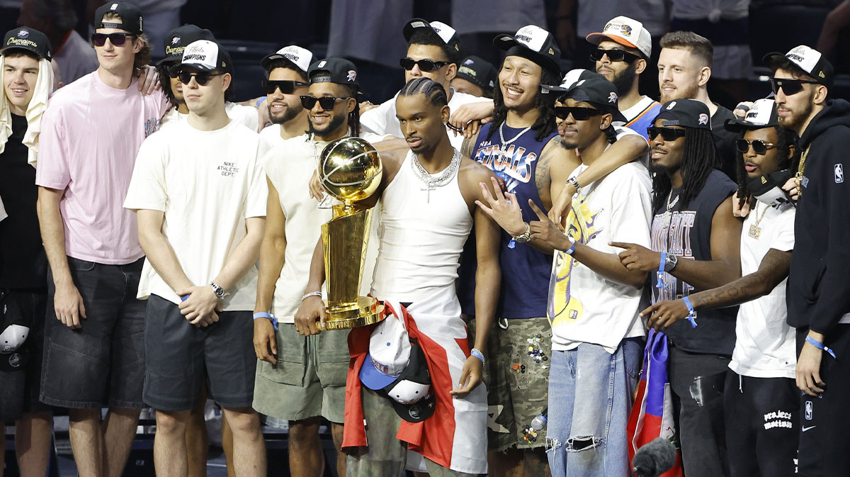 Thunder guard Shai Gilgeous-Alexander (2) holds the Larry OíBrien Championship Trophy with the team behind him during the Champions Opening Ceremony for the parade inside the Paycom Center with LeBron James and Kevin Durant in the background
