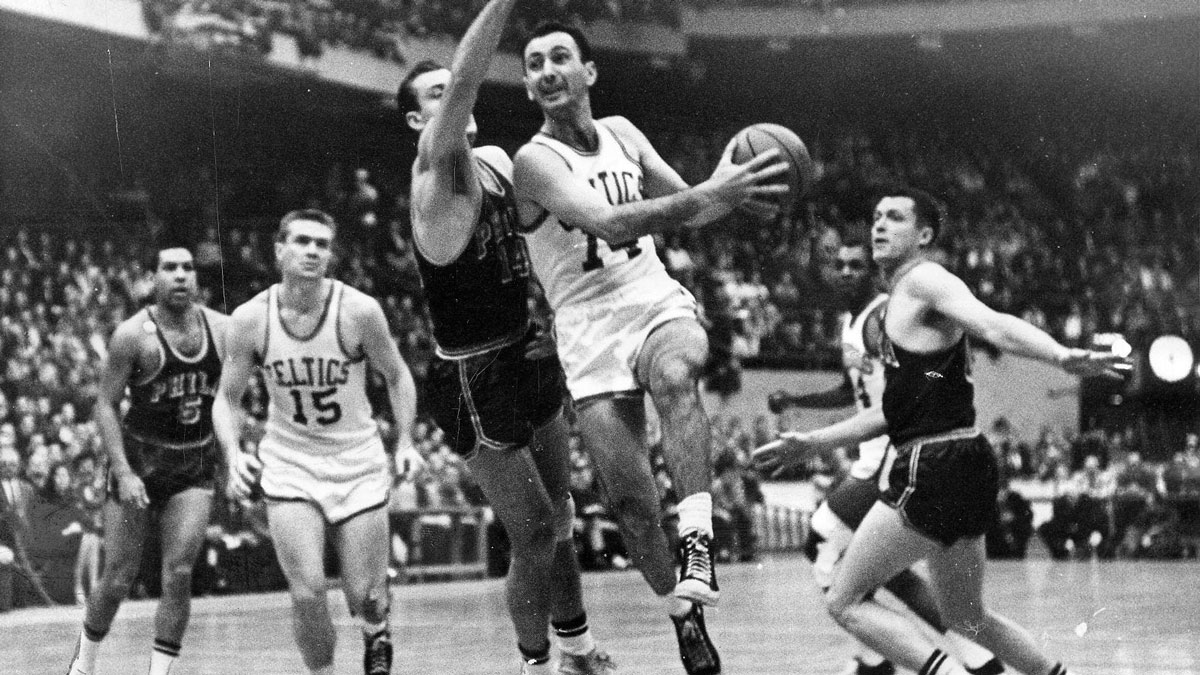 In a 1962 playoff game against Philadelphia, Tommy Heinsohn (15) is about to receive a pass from Bob Cousy, a fellow Holy Cross graduate.