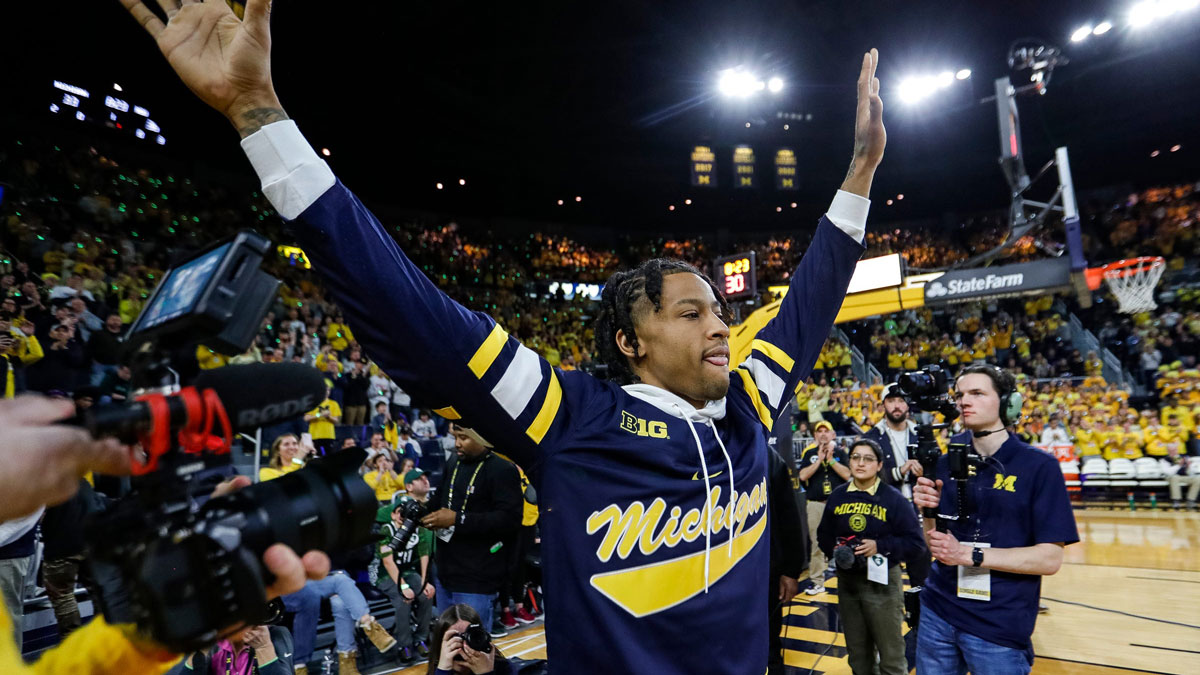 Trey Burke waves at the crowd during halftime as Michigan honors the 10-year anniversary of the 2013 run to the Final Four and national title game at Crisler Center