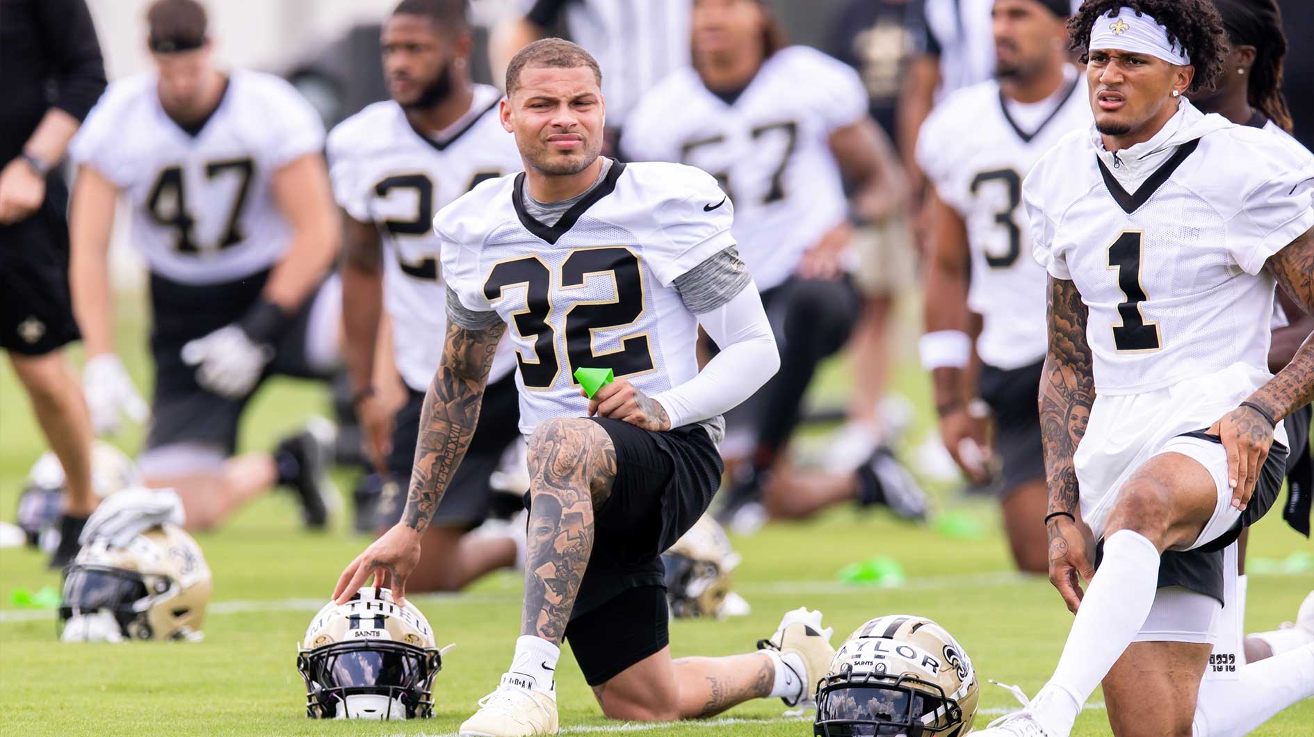 New Orleans Saints safety Tyrann Mathieu (32) and cornerback Alontae Taylor (1) look on during stretches during minicamp at Ochsner Sports Performance Center.