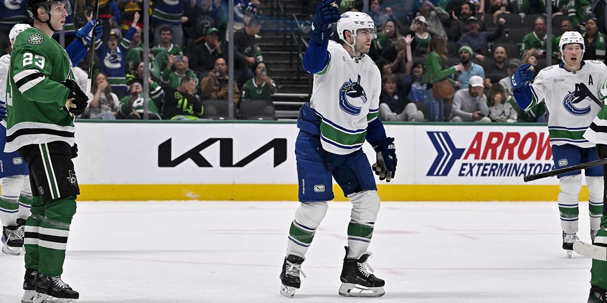 Vancouver Canucks left wing Jake DeBrusk (74) celebrates center Pius Suter (not pictured) scoring the game tying goal against the Dallas Stars during the third period at the American Airlines Center.