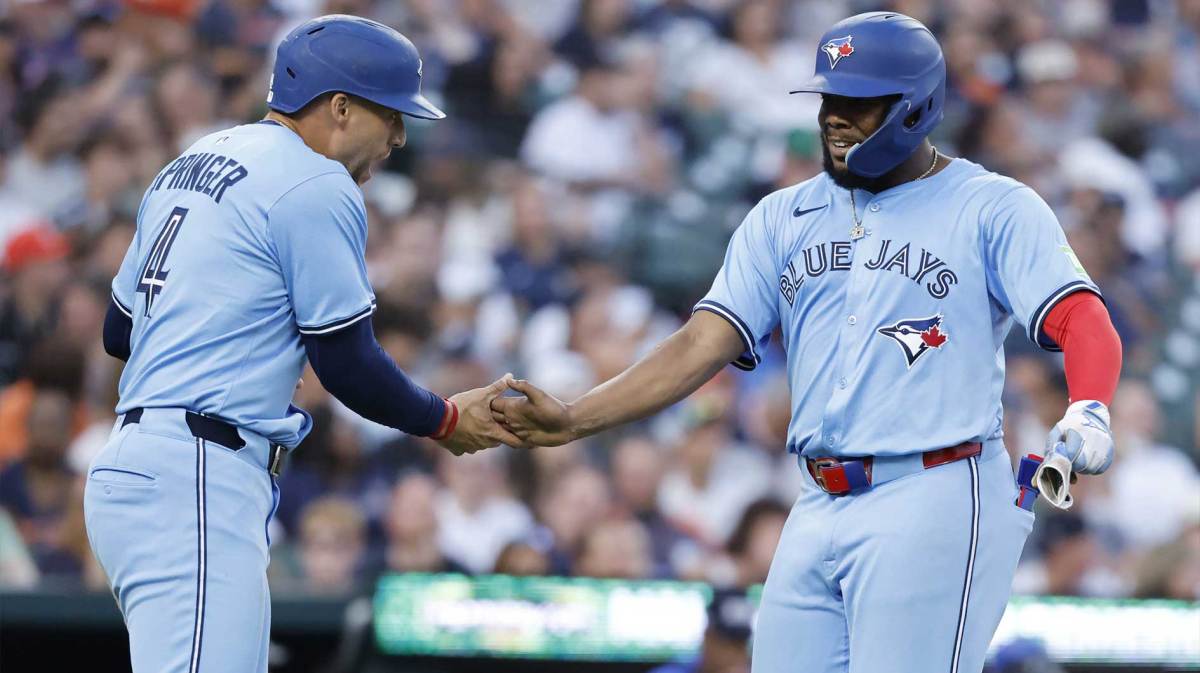Toronto Blue Jays outfielder George Springer (4) and first baseman Vladimir Guerrero Jr. (27) congratulate each other after scoring in the fifth inning against the Detroit Tigers at Comerica Park.