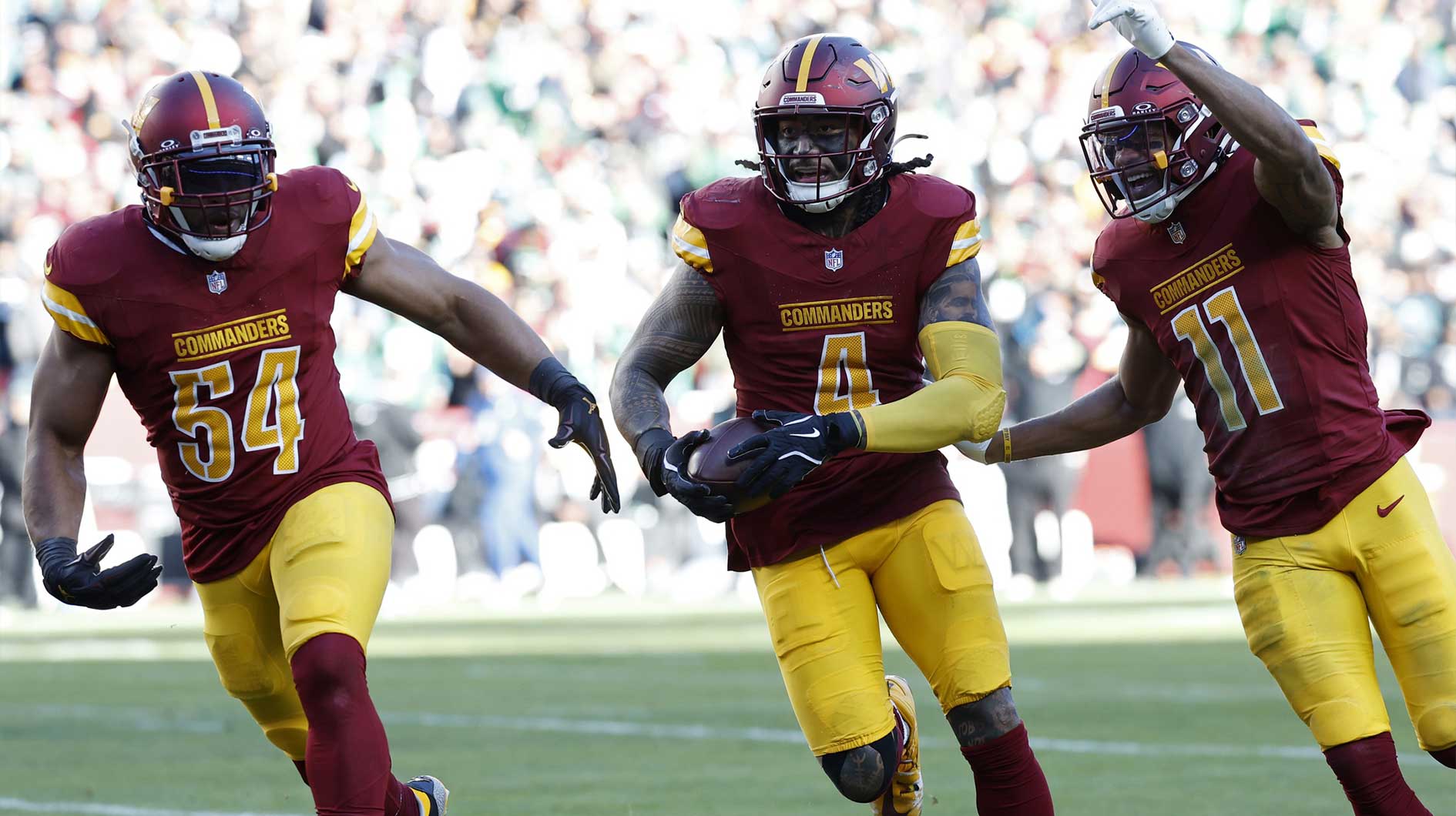 Washington Commanders linebacker Frankie Luvu (4) celebrates with teammates after intercepting a pass against the Philadelphia Eagles during the first quarter at Northwest Stadium.
