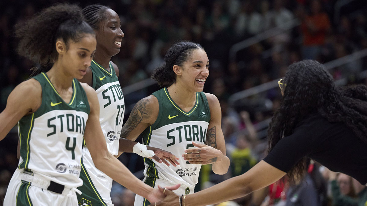 Seattle Storm guard Skylar Diggins (4), Seattle Storm forward Ezi Magbegor (13) and Seattle Storm forward Gabby Williams (5) are greeted by head coach Nowlle Quinn during a time out against the Connecticut Sun during the second half at Climate Pledge Arena.