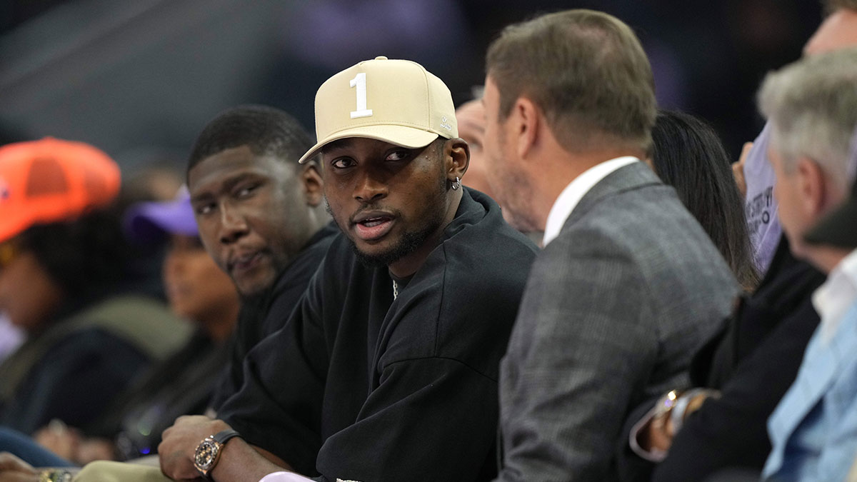 Warriors forward Jonathan Kuminga (center left) talks with owner Joe Lacob (center right) during the second quarter of the game between the Golden State Valkyries and the Los Angeles Sparks at Chase Center