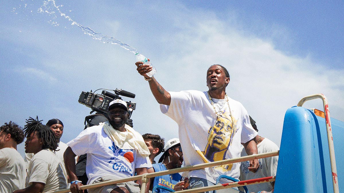 Oklahoma City Thunder player Jalen Williams splashes water on fans during the 2025 NBA Oklahoma City Thunder championship parade.
