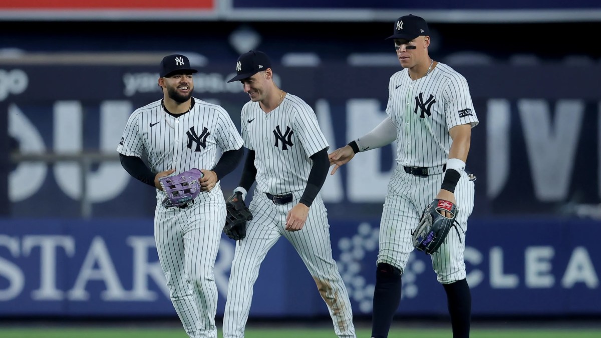 New York Yankees left fielder Jasson Dominguez (24) and center fielder Cody Bellinger (35) and right fielder Aaron Judge (99) celebrate after defeating the Seattle Mariners at Yankee Stadium.