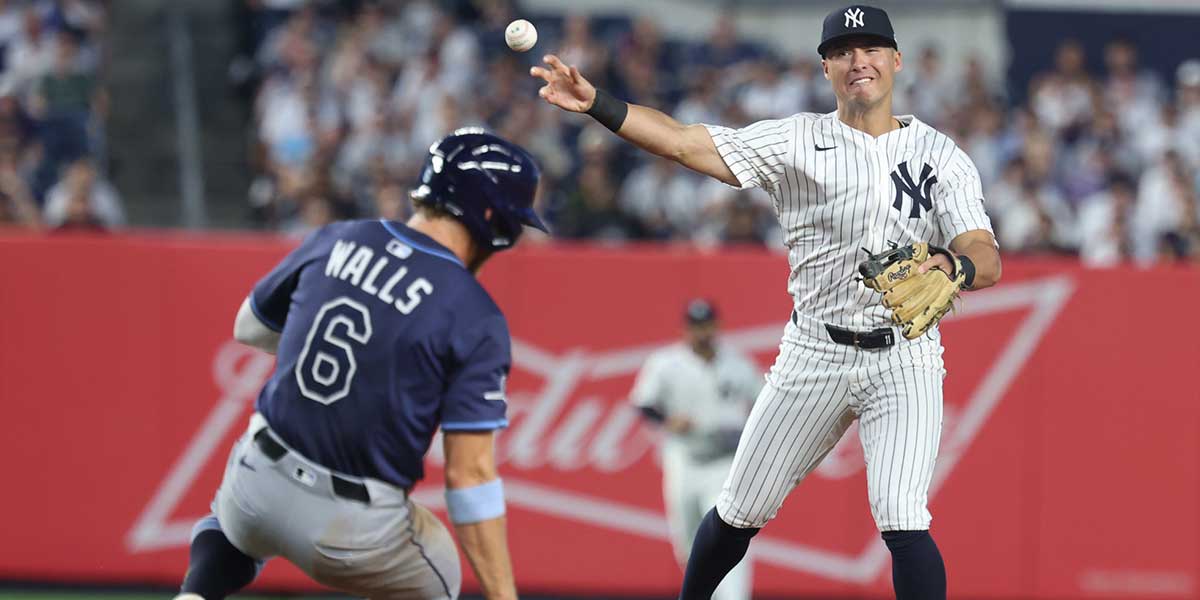 New York Yankees shortstop Anthony Volpe (11) forces out Tampa Bay Rays shortstop Taylor Walls (6) at second base and throws to first to complete the double play on a ball hit by center fielder Chandler Simpson (not pictured) at Yankee Stadium.