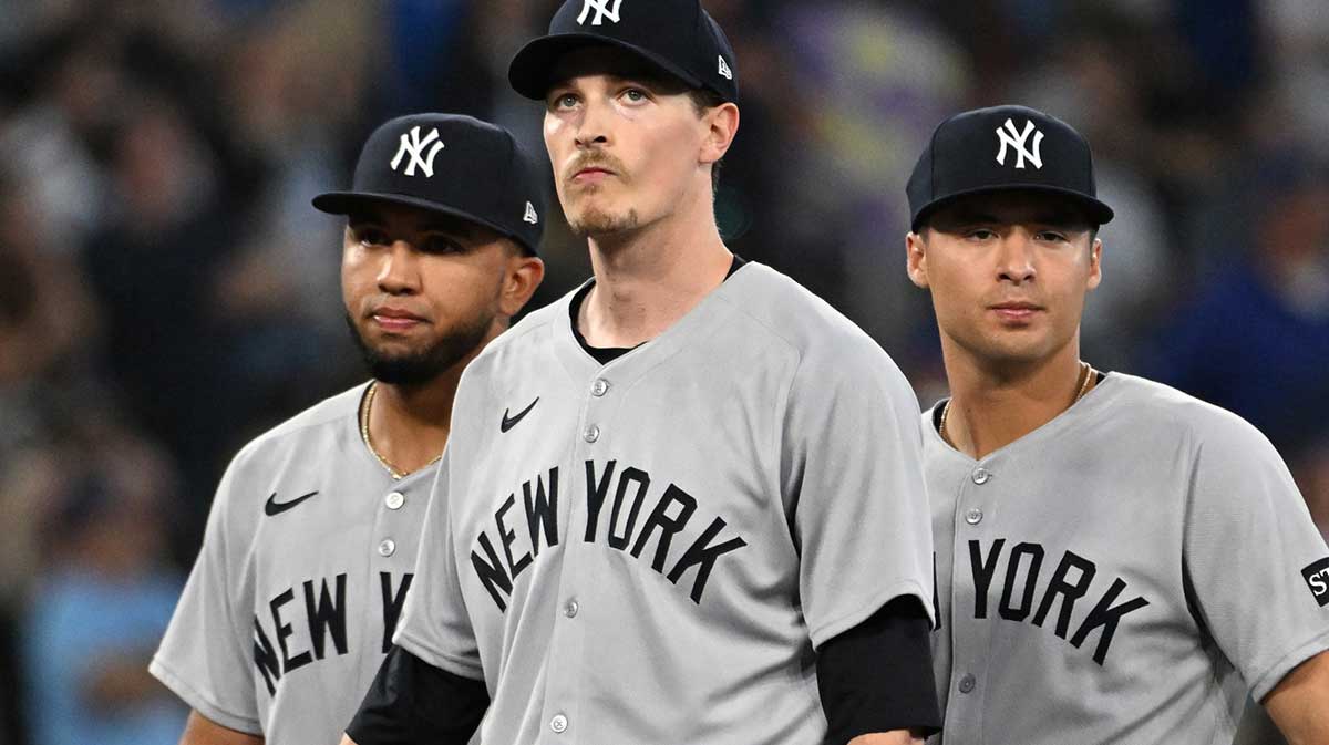 New York Yankees starting pitcher Max Fried (54) stands between third baseman Oswald Peraza (18, left) and shortstop Anthony Volpe (11) as he waits to be relieved in the sixth inning against the Toronto Blue Jays at Rogers Centre.