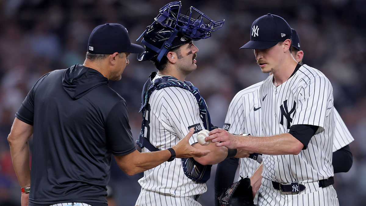 New York Yankees starting pitcher Max Fried (54) hands the ball to manager Aaron Boone (17) during a pitching change during the seventh inning against the Tampa Bay Rays at Yankee Stadium.