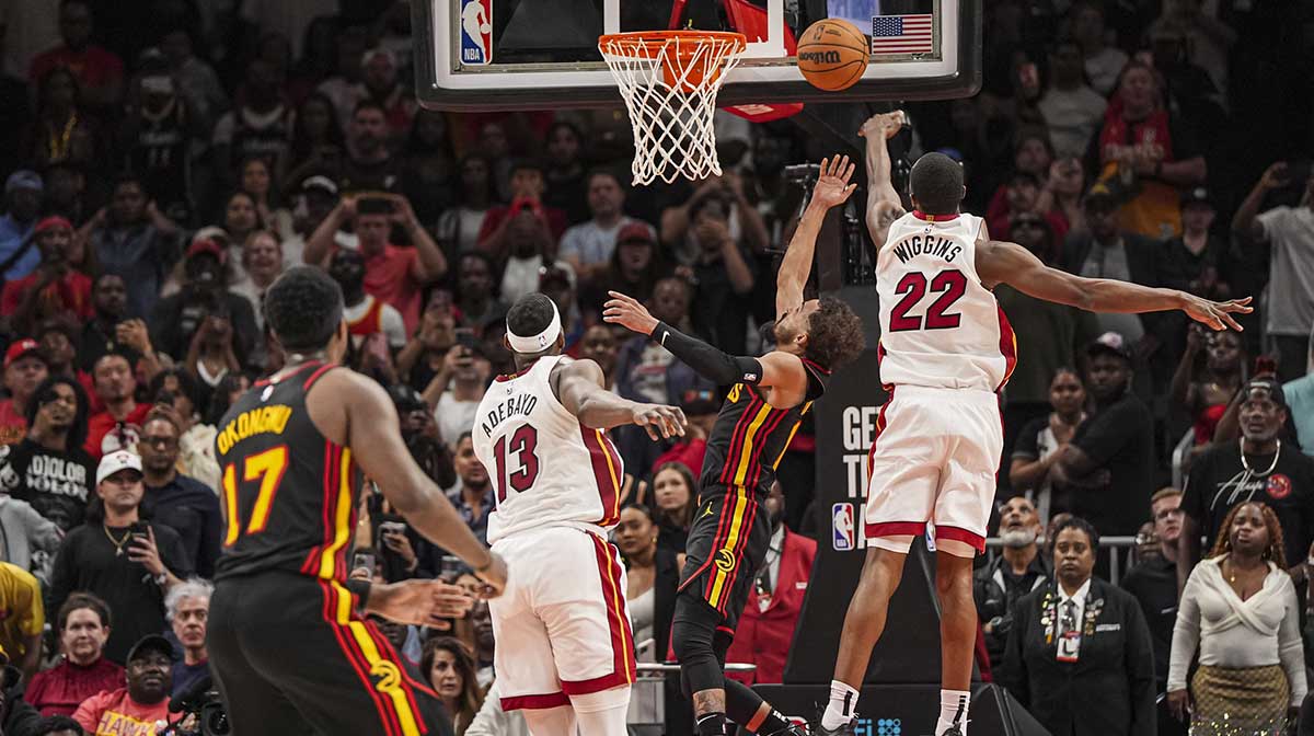 Atlanta Hawks guard Trae Young (11) ties the game in the final seconds behind Miami Heat forward Andrew Wiggins (22) during the second half at State Farm Arena.