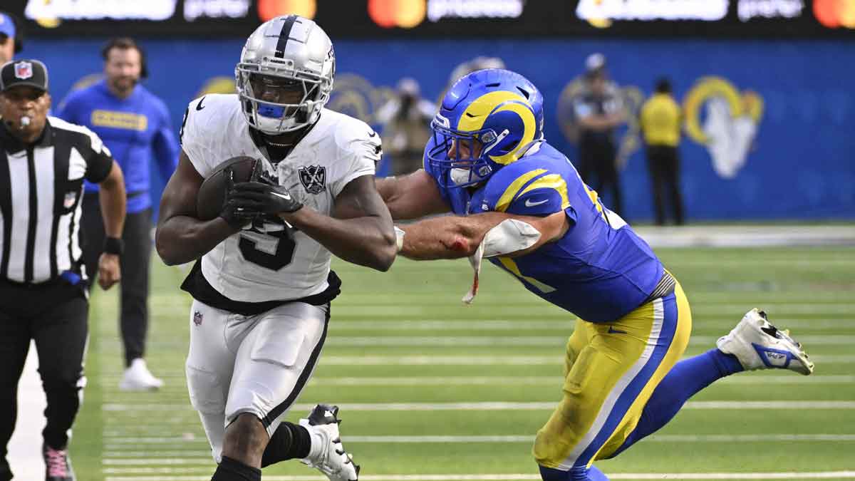 Los Angeles Rams linebacker Troy Reeder (51) pushes Las Vegas Raiders running back Zamir White (3) out-of-bounds after a catch during the second half at SoFi Stadium.