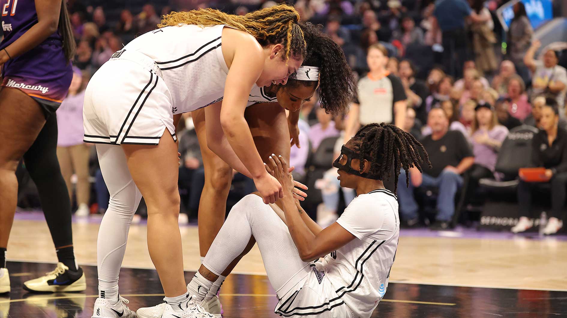 Golden State Valkyries teammates help up guard Tiffany Hayes (15) after drawing a charge during the first quarter against the Phoenix Mercury at Chase Cente
