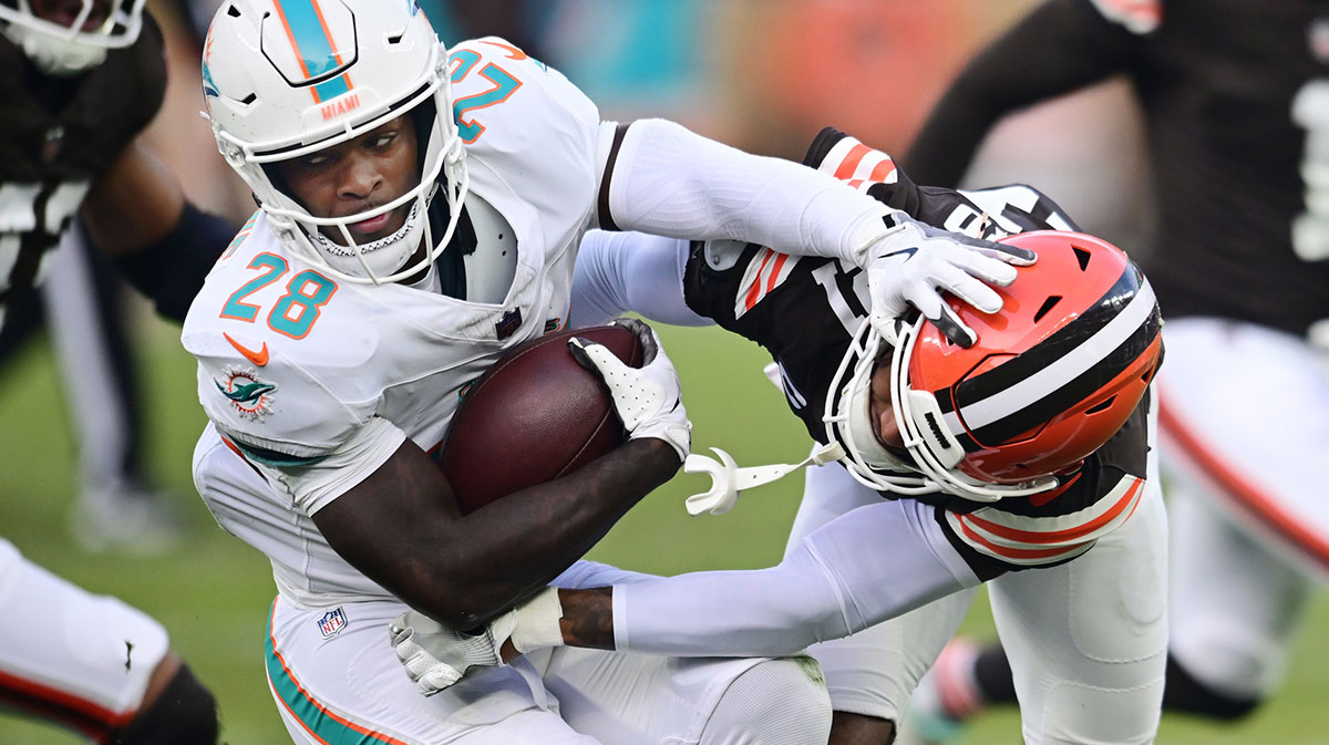 Cleveland Browns cornerback Denzel Ward (21) tackles Miami Dolphins running back De'Von Achane (28) during the first half at Huntington Bank Field.