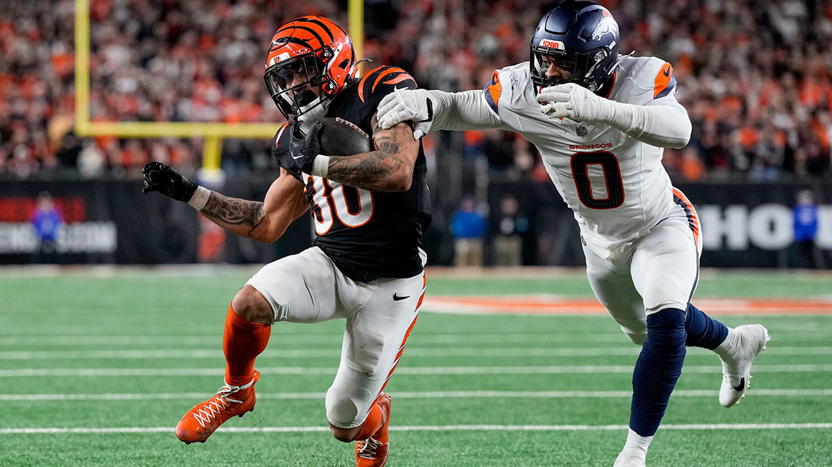 Cincinnati Bengals running back Chase Brown (30) is stopped short of the end zone by Denver Broncos linebacker Jonathon Cooper (0) on a carry in the fourth quarter of the NFL Week 17 game between the Cincinnati Bengals and the Denver Broncos at Paycor Stadium in downtown Cincinnati on Saturday, Dec. 28, 2024. The Bengals took a 30-24 win in overtime to remain in the post season chase.
