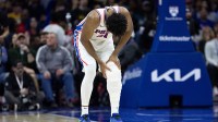 Philadelphia 76ers center Joel Embiid (21) holds his leg after a play against the Brooklyn Nets during the second quarter at Wells Fargo Center.