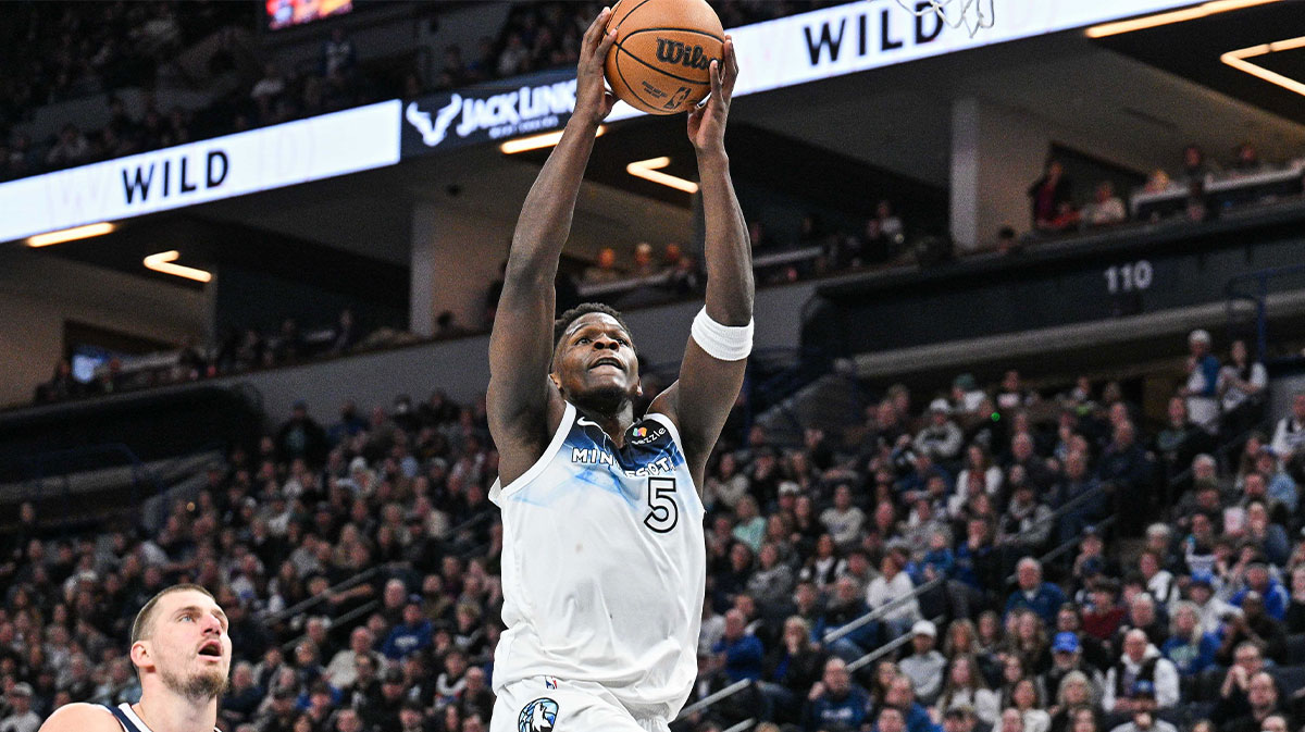 Minnesota Timberwolves guard Anthony Edwards (5) goes to the basket for a slam dunk over Denver Nuggets center Nikola Jokic (15) during the third quarter at Target Center.