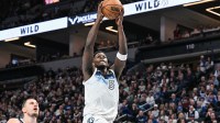 Minnesota Timberwolves guard Anthony Edwards (5) goes to the basket for a slam dunk over Denver Nuggets center Nikola Jokic (15) during the third quarter at Target Center.