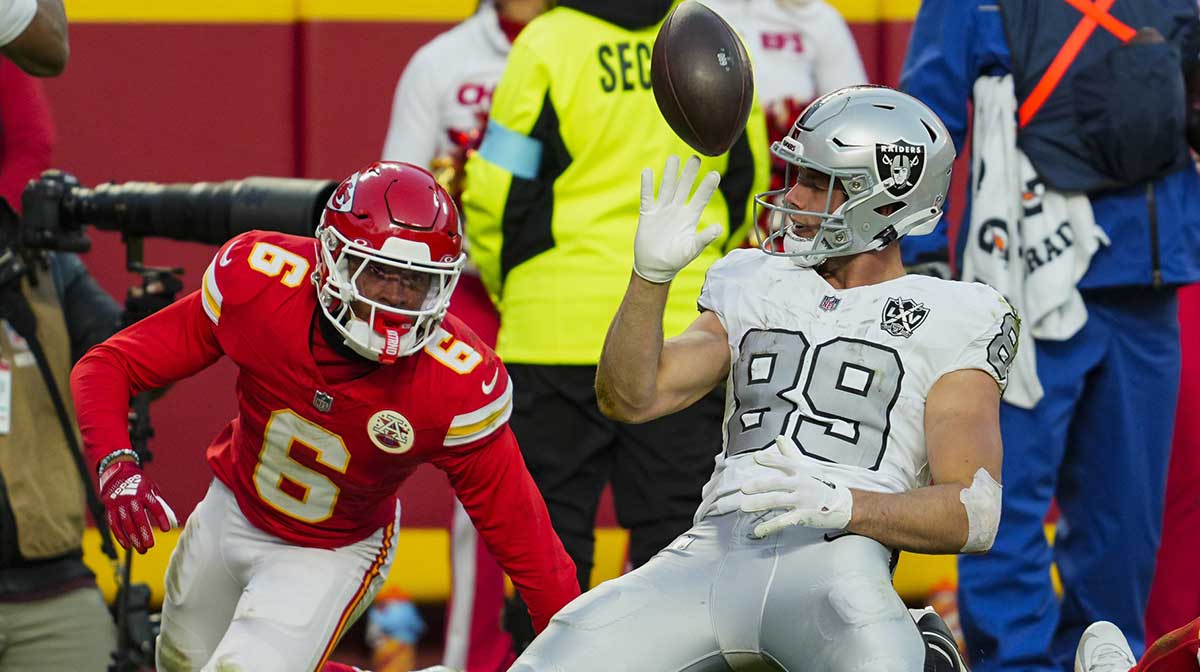 Las Vegas Raiders tight end Brock Bowers (89) tosses the ball after scoring a touchdown against Kansas City Chiefs safety Bryan Cook (6) during the second half at GEHA Field at Arrowhead Stadium.