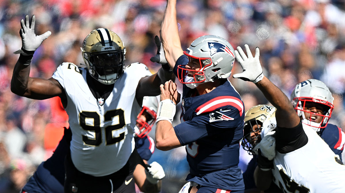 New England Patriots quarterback Mac Jones (10) throws under pressure from New Orleans Saints defensive end Tanoh Kpassagnon (92) during the first half at Gillette Stadium.