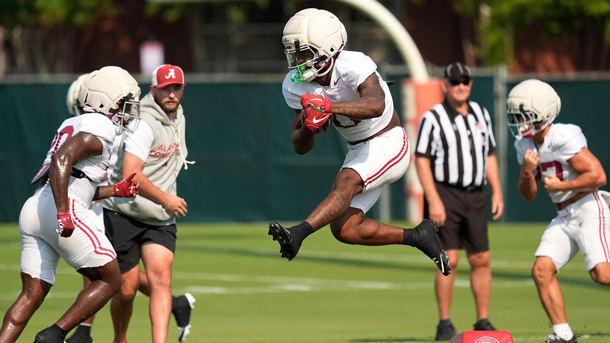 Running back AK Dear leaps over a bag tossed in his patch during practice for the Alabama Crimson Tide.