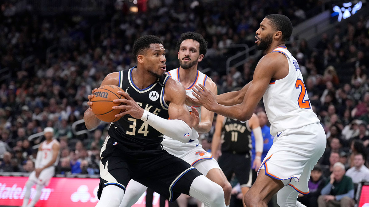 Milwaukee Bucks forward Giannis Antetokounmpo (34) puts up a shot against New York Knicks guard Landry Shamet (44) and New York Knicks forward Mikal Bridges (25) in the first half at Fiserv Forum.