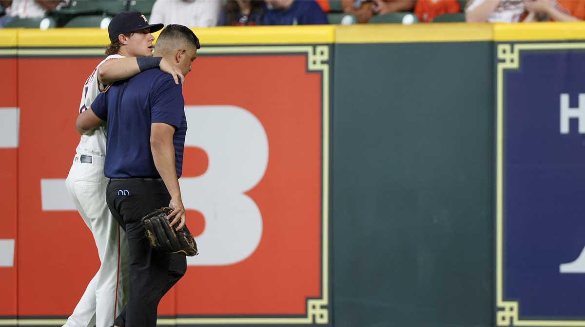 Houston Astros center fielder Jake Meyers (6) is helped off the field by a trainer before the game against the Cleveland Guardians at Daikin Park.