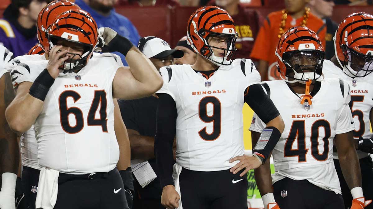 Bengals quarterback Joe Burrow (9) prepares to take to the field against the Washington Commanders during the first quarter at Northwest Stadium with Fox Sports 1's Colin Cowherd in the background