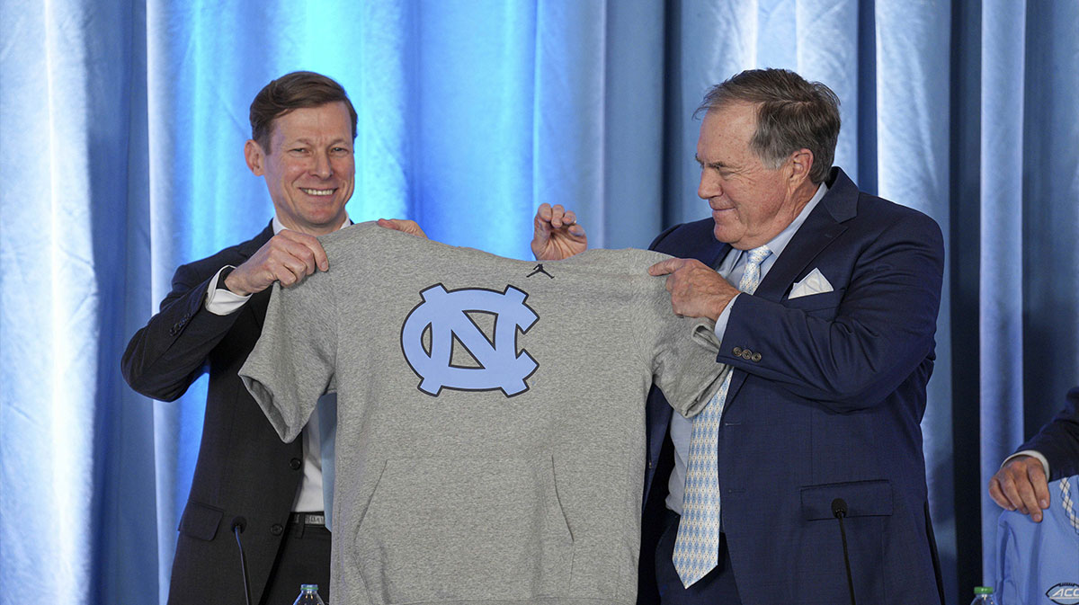 North Carolina Tar Heels chancellor Lee Roberts presents a cut off sweatshirt to new head coach Bill Belichick at Loudermilk Center for Excellence.