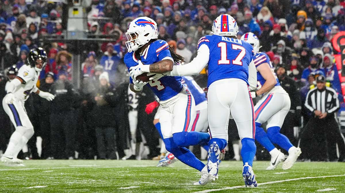 Buffalo Bills quarterback Josh Allen (17) hands the ball off to Buffalo Bills running back James Cook (4) during the first quarter against the Baltimore Ravens in a 2025 AFC divisional round game at Highmark Stadium. 