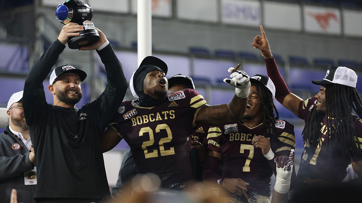 Bobcats head coach GJ Kinne celebrates with the trophy after the game against the North Texas Mean Green at Gerald J. Ford Stadium.