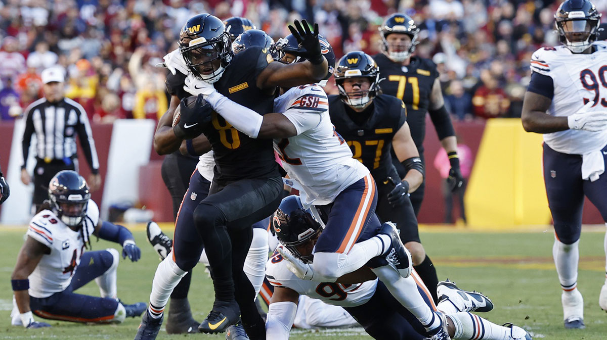 Washington Commanders running back Brian Robinson Jr. (8) carries the ball as Chicago Bears safety Elijah Hicks (22) makes the tackle during the first quarter at Northwest Stadium.